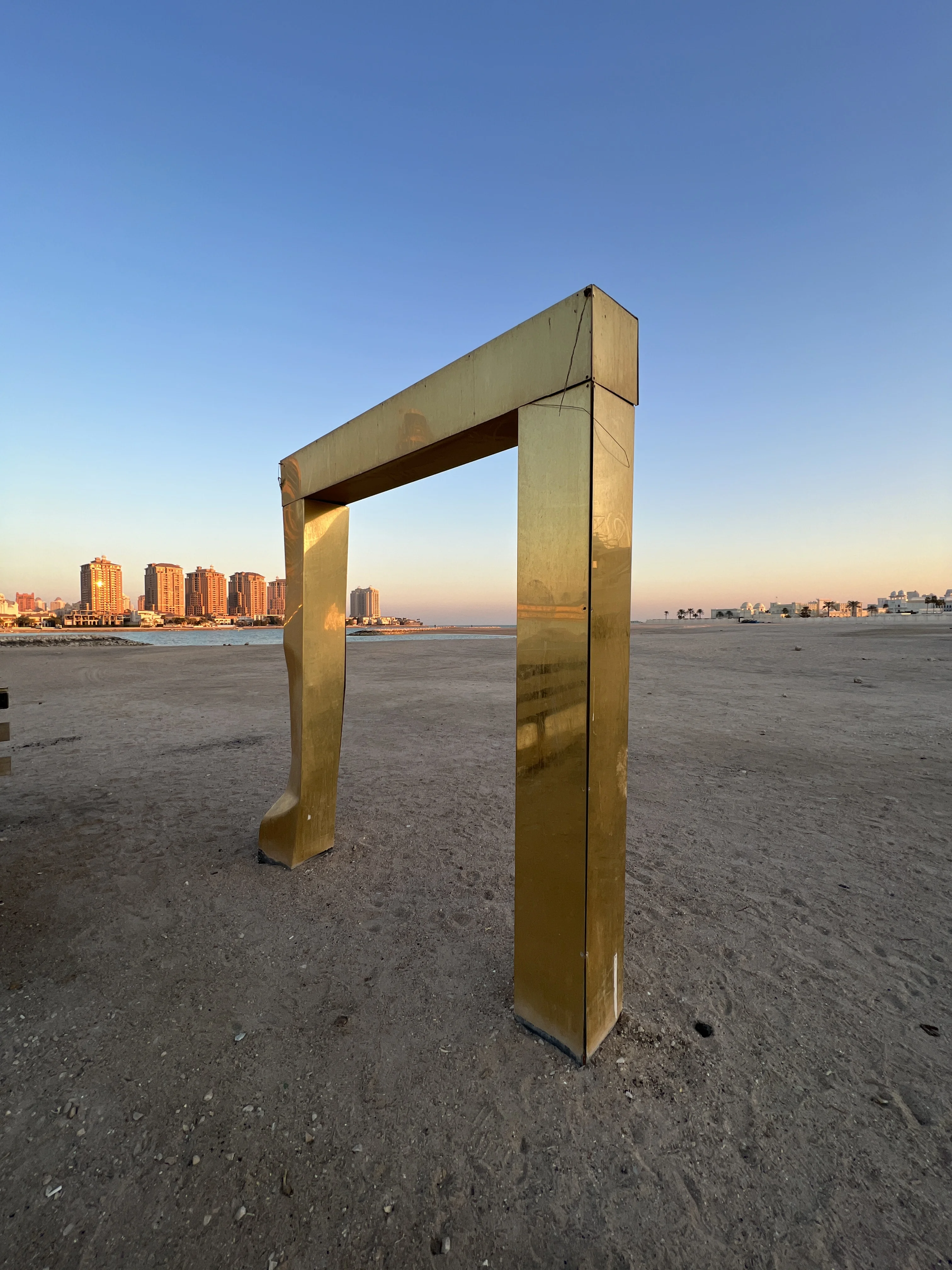 Gold rectangular frame sculpture on the West Bay Lagoon shoreline, Doha