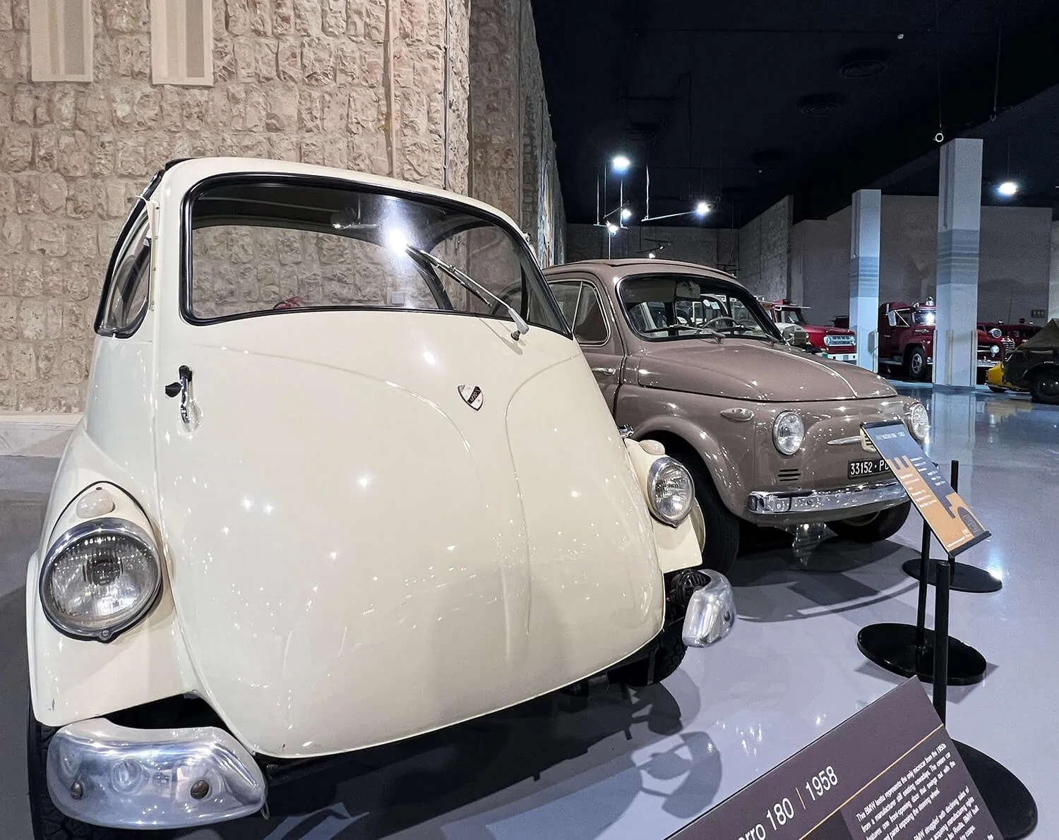 Vintage microcars on display, including a rounded bubble car