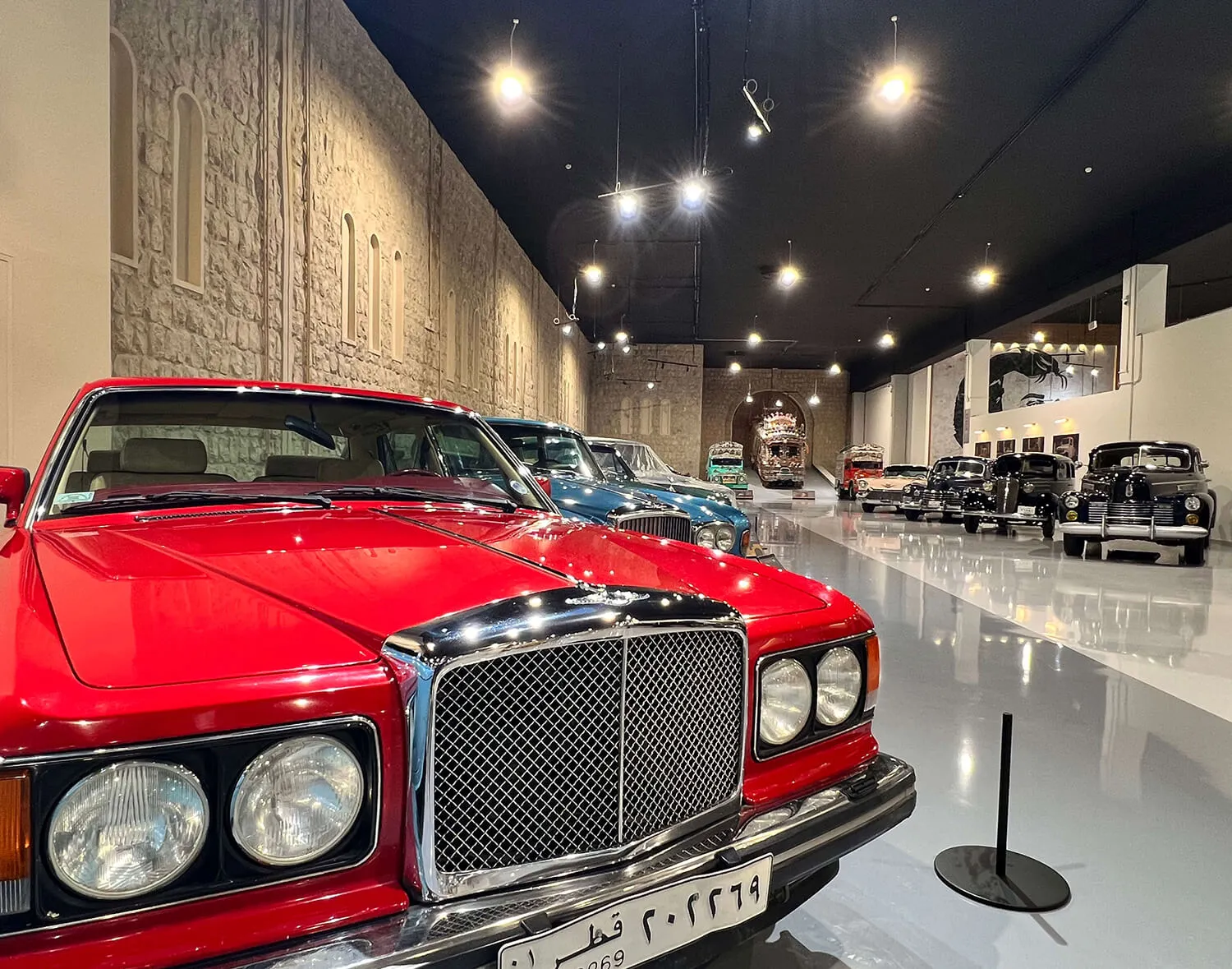 Red vintage car with a prominent chrome grille on display