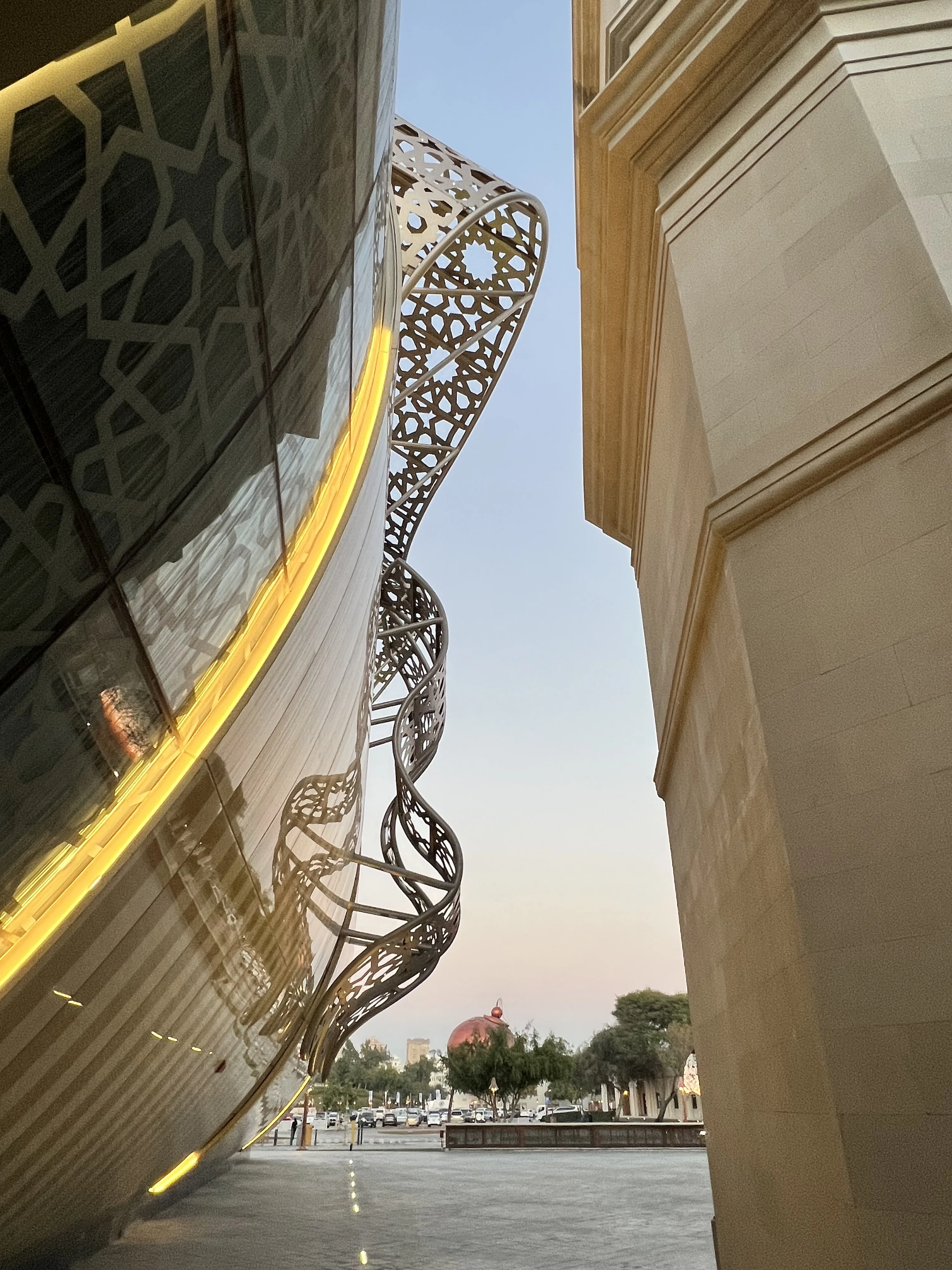 Gold spiral sculpture on the glass facade of 21 High Street shopping promenade, Katara