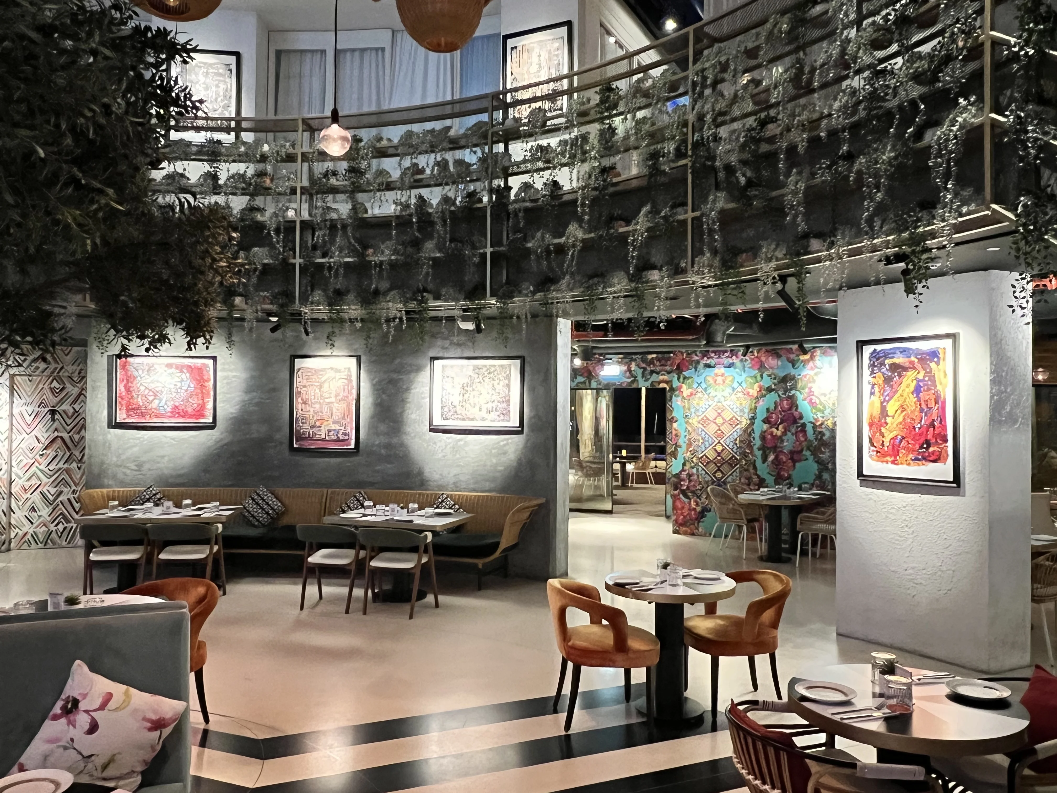 Bohemian-styled dining room with hanging plants and colourful wall art at Boho Social, Doha