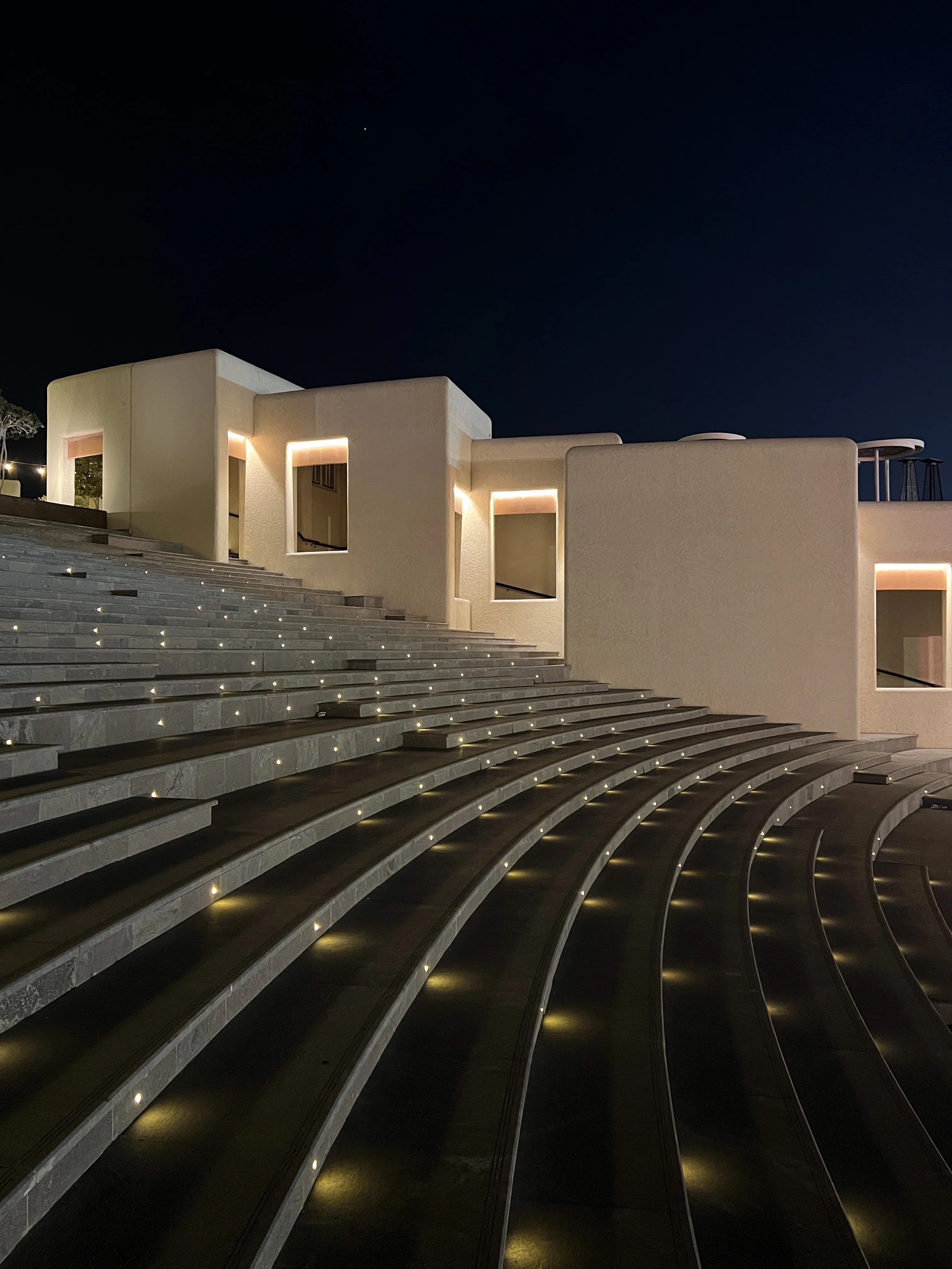 Curved stone amphitheatre steps illuminated at night at Katara Cultural Village, Doha