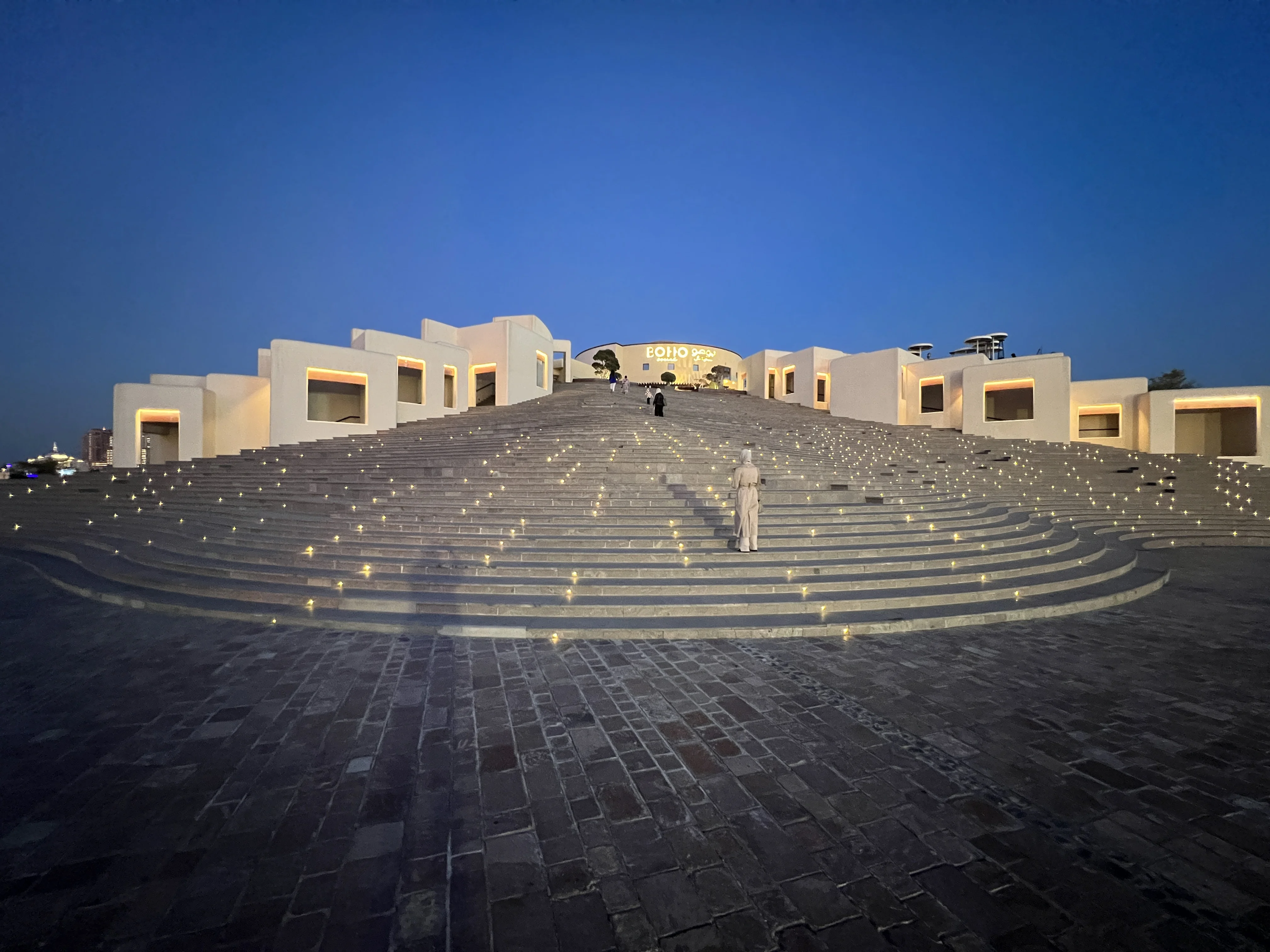 Katara Amphitheatre's exterior staircase and stone plaza at twilight