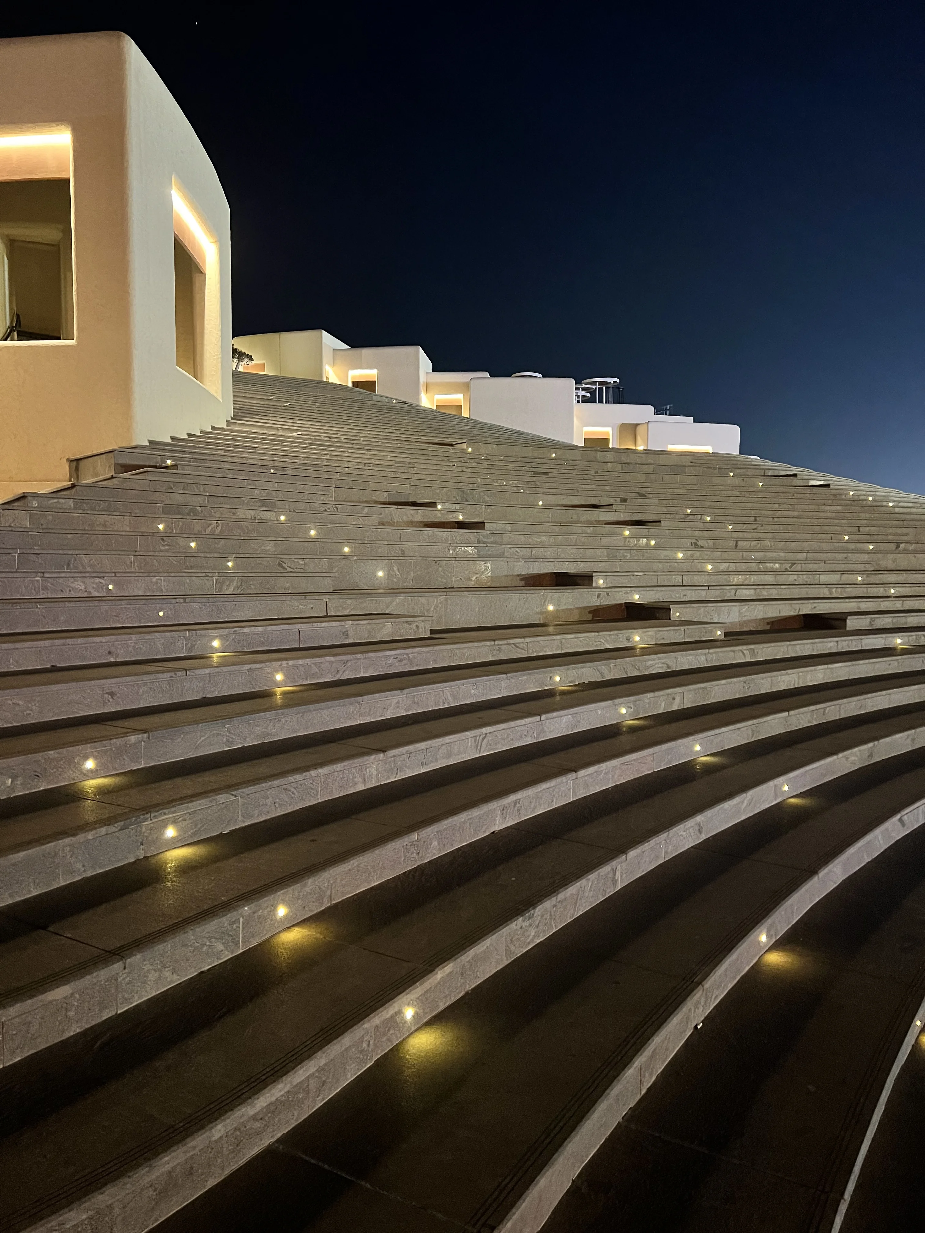 Tiered limestone seating arena at Katara Amphitheatre at night