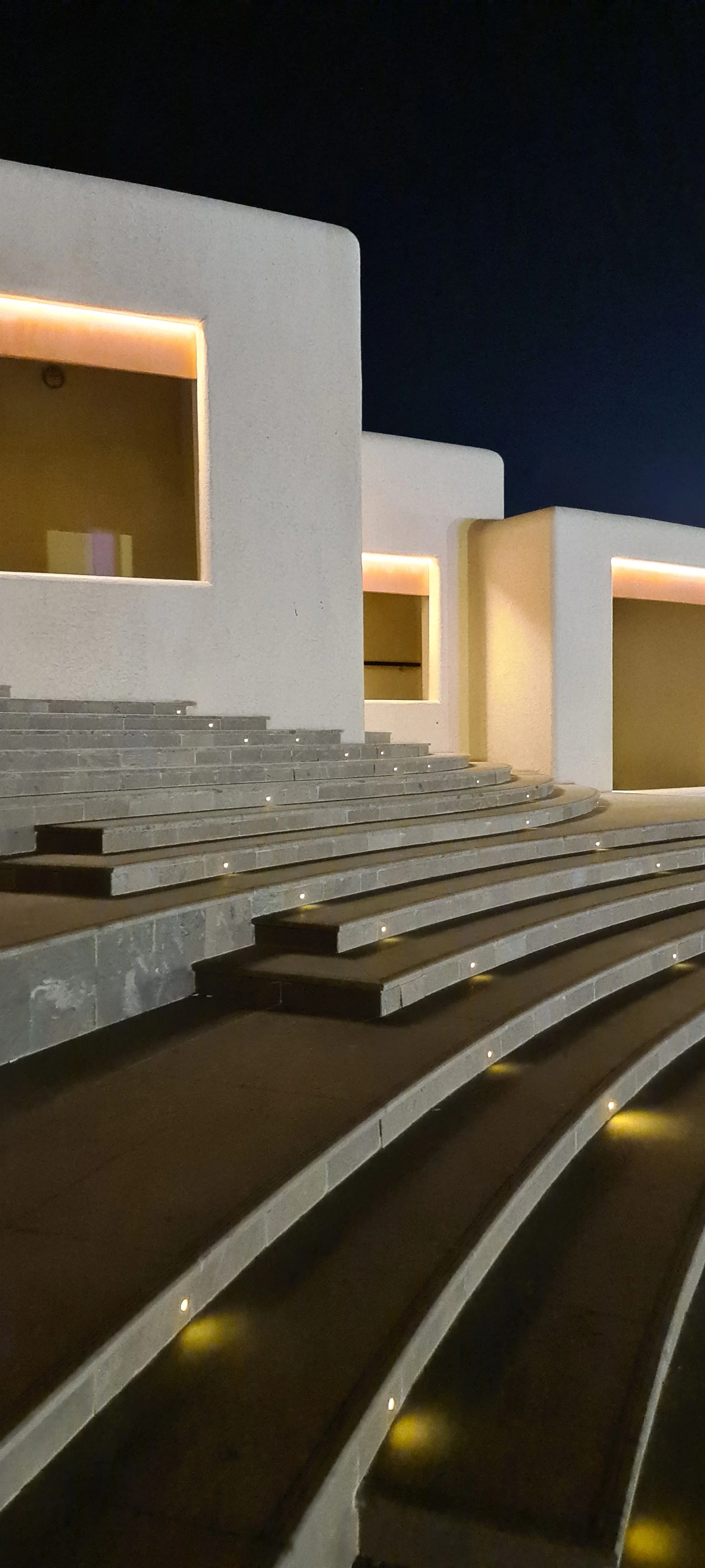 Illuminated building beside Katara Amphitheatre at night, Katara Cultural Village